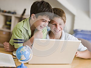 Two Young Boys Using A Laptop At Home