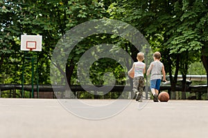 Two young boys walking off a basketball court
