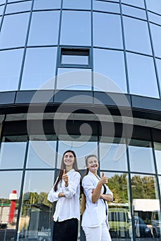 Two young business ladies negotiating near business center