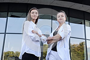 Two young business ladies negotiating near business center