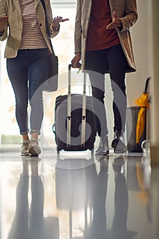 Two young business people are walking through a hotel hallway during a business trip. Business, people, hotel, trip