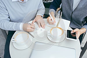 Two young businessmen are chatting in a coffee shop. - Image