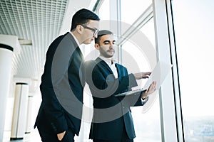 Two young businessmen discussing project