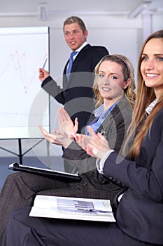 Two young businesswoman clapp their hands