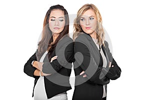Two young businesswoman leaning againts each other, isolated