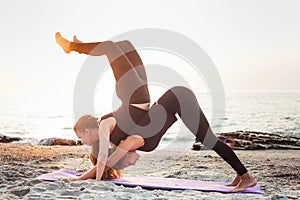 Two young caucasian females practicing yoga on beach