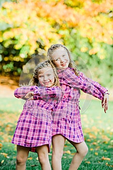 Two Young Caucasian Sisters Strike a Pose in Matching Pink Flannel Dresses
