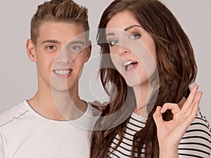 Two young cheerful people OK sign