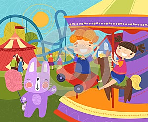 Two young children having fun at the fairground riding on a colorful carousel or merry-go-round watched by their pet