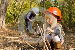 Two young children playing at being builders