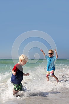 Two Young Children Playing and Splashing in Ocean Water