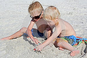 Two Young Children Playing Toys in the Sand at the Beach