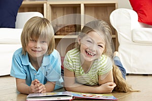 Two Young Children Reading Book at Home photo