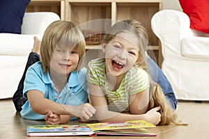 Two Young Children Reading Book at Home photo