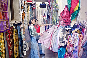 Two young Chinese women looking at typical clothes in the typical handicraft photo