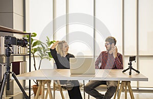 Two young content creator discussing while filming themselves live stream on making online show