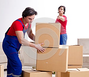 Two young contractor employees moving personal belongings