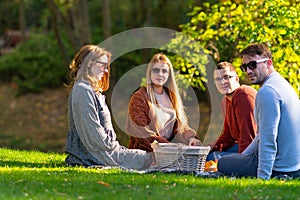 Two young couples enjoying an autumn picnic