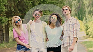 Two young couples posing embraced for camera, enjoying summer outdoor activities