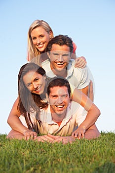 Two, young couples posing on a field