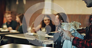 Two young couples rest in a cafe in the evening. Men and women drink coffee with milk.