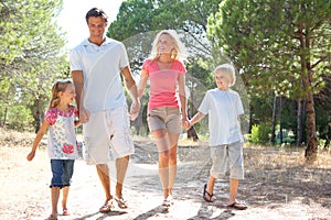 Two young couples, together, running in park