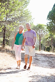 Two young couples, together, running in park