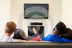 Two Young Couples Watching Television At Home Together