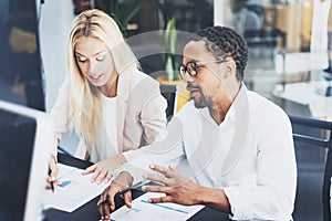 Two young coworkers working together in a modern office.Man wearing glasses and discussing with woman new project.Horizontal,blur