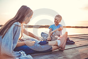 Two young cute little friends, boy and girl talking while sitting during sunset
