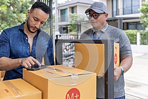 Two Young Delivery Man Carrying Cardboard Box and check the items in the cardboard box