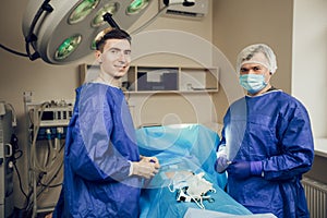 Two young doctors in uniform in the operating room.