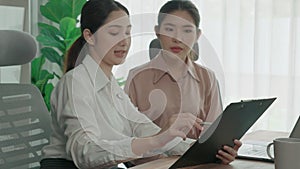 Two young enthusiastic businesswoman working together in the office workspace.