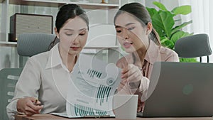 Two young enthusiastic businesswoman working together in the office workspace.