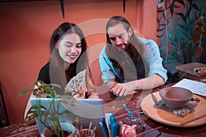 Two young entrepreneurs who own a pottery business. generate enough income from the business to expand the business to accommodate