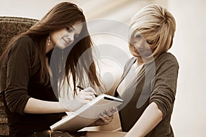 Two young fashion business women with notebook