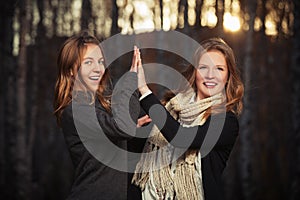 Two young fashion girls in black pullover and scarf walking outdoor