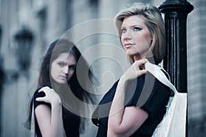 Two young fashion women with handbags