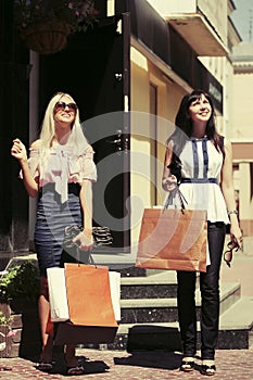 Two young fashion women with shopping bags