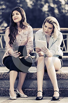 Two young fashion women using digital tablet computer