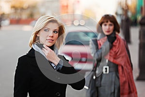 Two young fashion women walking on a city street