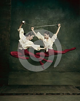 Two young female ballet dancers like duelists with swords. Ballet and contemporary choreography concept. Creative art