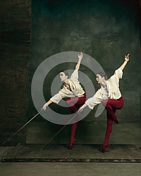 Two young female ballet dancers like duelists with swords. Ballet and contemporary choreography concept. Creative art