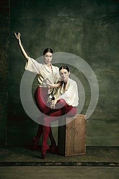 Two young female ballet dancers like duelists with swords. Ballet and contemporary choreography concept. Creative art photo