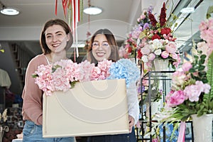 Two Young female florists' partner delivers a floral bunch with a happy smile.