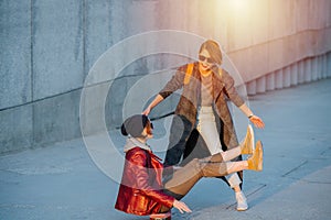 Two young female friends having fun with skateboard together