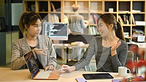 Two young female software programmer or coder discussing detail of project developing website design and coding