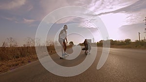 Two young fit women cruising on longboards during summer vacations