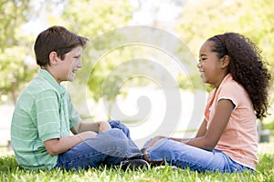 Two young friends sitting outdoors looking at each photo