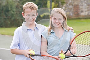Two young friends on tennis court smiling